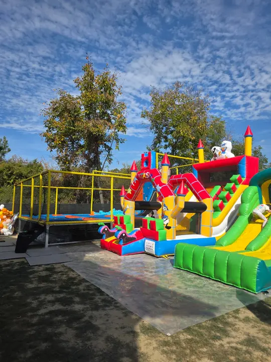 Parcul gonflabil și arena de trambuline văzute de departe, cu copaci în fundal